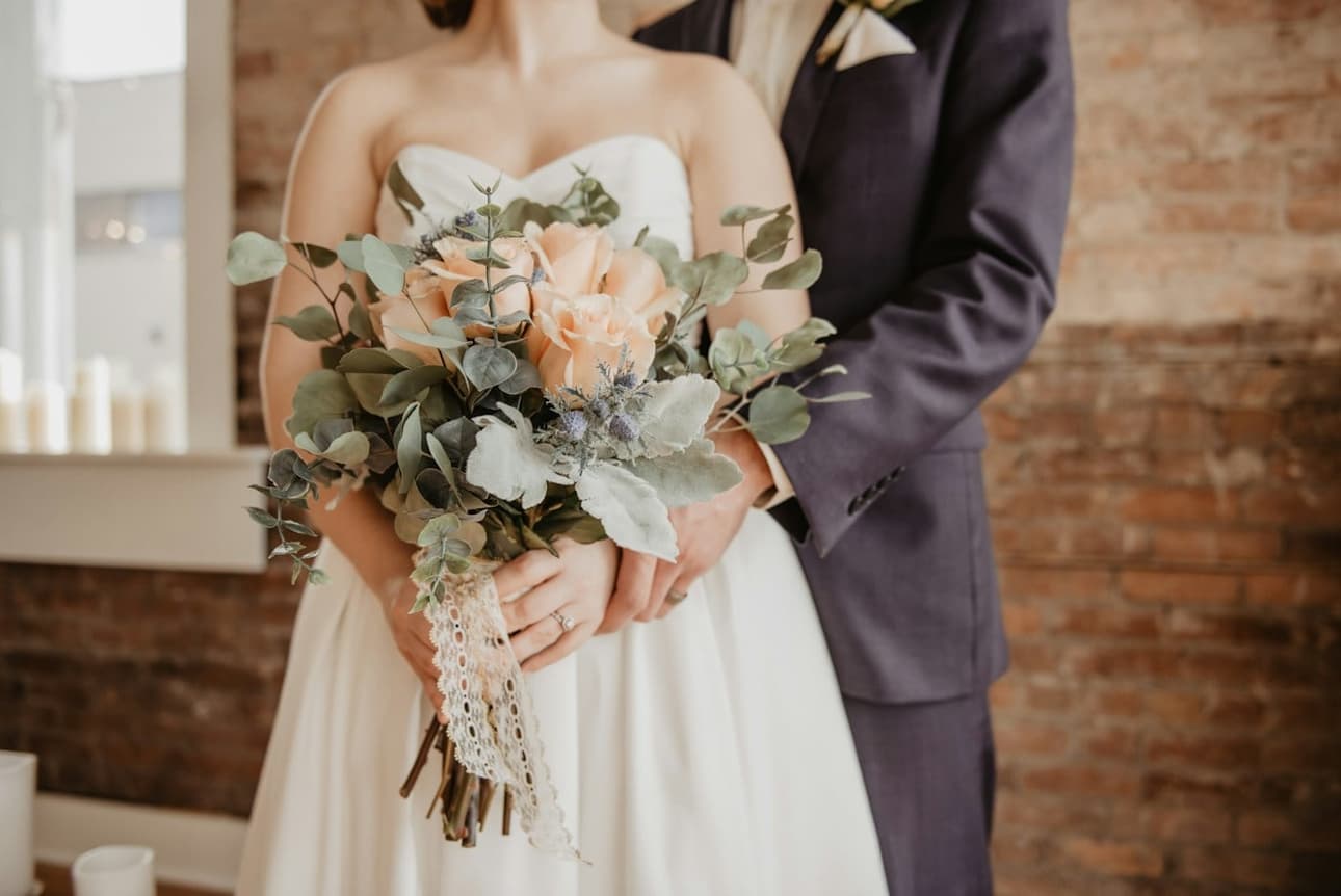 The couple holding the bouquet together