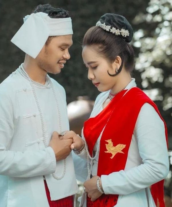 The couple in Mon traditional dress holding hands